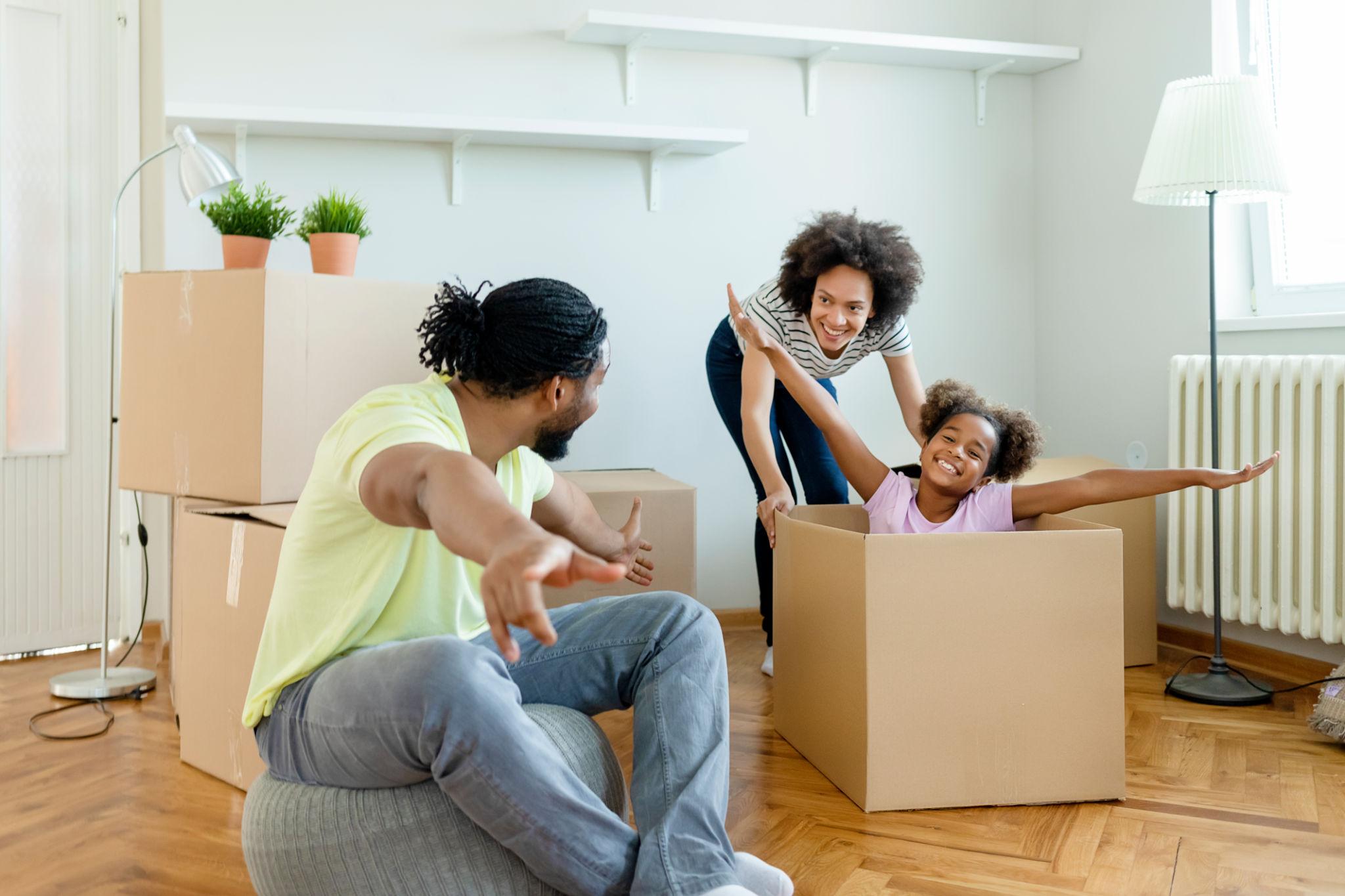 A happy family playing among moving boxes in their new home